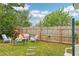 Charming backyard with a wooden fence, garden furniture, and a lush green lawn under a bright sky at 1301 North Ave, Tavares, FL 32778