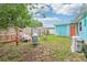 Cozy backyard featuring a wooden fence, colorful furniture, and a vibrant turquoise shed with an orange door at 1301 North Ave, Tavares, FL 32778