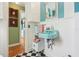 Stylish bathroom with a vintage light blue sink, black and white checkered floor, and bright teal accent wall at 1301 North Ave, Tavares, FL 32778