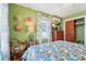 Comfortable bedroom showcasing a tropical bedspread, natural light, and a cozy seating area at 1301 North Ave, Tavares, FL 32778