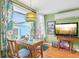 Cozy dining area featuring a bamboo table, tropical curtains, and a view of the outdoors at 1301 North Ave, Tavares, FL 32778