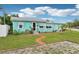 Charming turquoise home with white trim, a brick walkway, and well-manicured landscaping at 1301 North Ave, Tavares, FL 32778