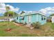 Adorable turquoise home with white trim, front garden and flower boxes on windows at 1301 North Ave, Tavares, FL 32778