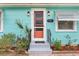 Close-up of front door with brick accents and updated sconces, surrounded by lush landscaping at 1301 North Ave, Tavares, FL 32778