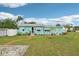 Attractive one-story home with light blue siding, complemented by green lawn and blue skies at 1301 North Ave, Tavares, FL 32778