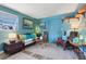 Cozy living room with blue walls, eclectic decor, comfortable seating, and natural light from the window at 1301 North Ave, Tavares, FL 32778