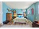 Charming bedroom with bright blue walls, vintage furniture, and a comfortable bed with stylish accents at 1301 North Ave, Tavares, FL 32778