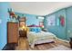 Comfortable bedroom with blue walls, vintage dressers and a comfortable bed with green and blue linens at 1301 North Ave, Tavares, FL 32778