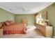Bedroom featuring a tan carpet, windows with decorative curtains, and a lighted ceiling fan at 13050 Se 89Th Cir, Summerfield, FL 34491