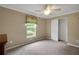 Bedroom with neutral carpet and a window with a light-blocking shade at 13050 Se 89Th Cir, Summerfield, FL 34491