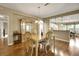 Open-concept dining room featuring a wooden table, chandelier, and wood floors at 13050 Se 89Th Cir, Summerfield, FL 34491