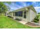 Exterior view of a sunroom, featuring windows and a doorway to the backyard at 13050 Se 89Th Cir, Summerfield, FL 34491