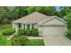 Charming home with lush landscaping, a two-car garage, and a well-maintained lawn at 13050 Se 89Th Cir, Summerfield, FL 34491