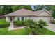 Charming single-story home with well-maintained landscaping, complemented by a two-car garage and inviting walkway at 13050 Se 89Th Cir, Summerfield, FL 34491