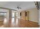 Spacious living room featuring hardwood floors, a ceiling fan, and a large wooden entertainment center at 13050 Se 89Th Cir, Summerfield, FL 34491