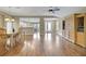 Open concept living room with hardwood floors and views of kitchen and entry at 13050 Se 89Th Cir, Summerfield, FL 34491