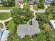 Aerial view of a home surrounded by mature trees and lush landscaping in a peaceful residential neighborhood at 1341 W Lakeshore Dr, Clermont, FL 34711
