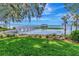 Picturesque backyard with lush lawn leading to a private wooden dock on a serene lake at 1341 W Lakeshore Dr, Clermont, FL 34711
