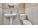 Half bathroom features wainscoting, pedestal sink, and modern fixtures at 1341 W Lakeshore Dr, Clermont, FL 34711