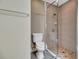 Bathroom featuring clear glass shower, beige tile, and matching toilet and hardware at 1341 W Lakeshore Dr, Clermont, FL 34711