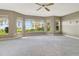 Spacious bedroom with neutral carpet, ceiling fan and an abundance of windows with beach views at 1341 W Lakeshore Dr, Clermont, FL 34711
