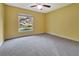 Bedroom with neutral carpet, yellow walls, and a window with a view of the yard at 1341 W Lakeshore Dr, Clermont, FL 34711