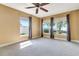 Bright bedroom with neutral carpet, ceiling fan, and beautiful exterior views from the many large windows at 1341 W Lakeshore Dr, Clermont, FL 34711