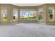 Light-filled room featuring neutral carpet, a ceiling fan, and multiple windows showcasing tranquil beach views at 1341 W Lakeshore Dr, Clermont, FL 34711