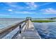 Scenic view down a long wooden dock, leading to covered area on the water at 1341 W Lakeshore Dr, Clermont, FL 34711