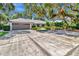 Wide driveway leading to a home with a grey garage door and lush landscaping at 1341 W Lakeshore Dr, Clermont, FL 34711