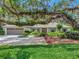Beautiful home with a well-manicured lawn, mature trees, and an attached two-car garage at 1341 W Lakeshore Dr, Clermont, FL 34711