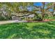 Well-kept lawn with mature shade trees in front of home and attached garage at 1341 W Lakeshore Dr, Clermont, FL 34711