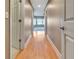 A home hallway with light wood flooring leading towards an open space with large windows at 1341 W Lakeshore Dr, Clermont, FL 34711