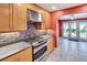 Close-up of updated kitchen with stainless steel oven, granite countertops, and wood cabinets at 1341 W Lakeshore Dr, Clermont, FL 34711