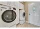 Laundry room with white washer and dryer and built-in cabinets at 1341 W Lakeshore Dr, Clermont, FL 34711