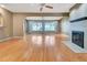 Bright living room with hardwood floors, a cozy fireplace, and picturesque water views through large windows at 1341 W Lakeshore Dr, Clermont, FL 34711