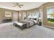 Bright main bedroom with ceiling fan, bay windows, beach views, bench and gray decor at 1341 W Lakeshore Dr, Clermont, FL 34711
