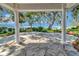 Spacious patio with stone flooring and white columns, offering serene waterfront views and outdoor living at 1341 W Lakeshore Dr, Clermont, FL 34711