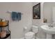 Well-lit bathroom with a pedestal sink, toilet, decorative art, and a modern touch at 14430 Desert Haven St # 4302, Windermere, FL 34786