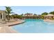 Spacious community pool with comfortable lounge chairs and nearby palm trees at 14430 Desert Haven St # 4302, Windermere, FL 34786