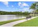Scenic view of a tranquil pond with a bench along a walking path, offering a peaceful outdoor retreat at 14430 Desert Haven St # 4302, Windermere, FL 34786