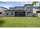 Expansive backyard view features a screened lanai, lush green grass, and a well-maintained home exterior at 14513 Winter Stay Dr, Winter Garden, FL 34787