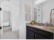 Bathroom boasts a black vanity with granite countertop and a view into an adjacent room at 14513 Winter Stay Dr, Winter Garden, FL 34787