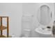 Cozy bathroom features a round mirror, pedestal sink, and wooden shelving at 14513 Winter Stay Dr, Winter Garden, FL 34787