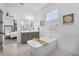 Bright bathroom features a soaking tub, gray vanity, and views into the main bedroom at 14513 Winter Stay Dr, Winter Garden, FL 34787