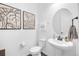 Small bathroom features a pedestal sink, modern lighting, and minimalist decor at 14513 Winter Stay Dr, Winter Garden, FL 34787