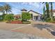 Elegant clubhouse exterior with stone accents, arched entryway, and beautifully landscaped grounds for a grand entrance at 14513 Winter Stay Dr, Winter Garden, FL 34787