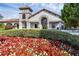 Elegant clubhouse featuring stone tower, arched entryway, and colorful flower beds enhancing its curb appeal at 14513 Winter Stay Dr, Winter Garden, FL 34787