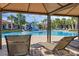 Community pool with waterpark as seen from covered sitting area with lounge chairs at 14513 Winter Stay Dr, Winter Garden, FL 34787