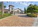 Attractive exterior of clubhouse showcasing manicured landscaping, stone accents, and a lovely brick driveway at 14513 Winter Stay Dr, Winter Garden, FL 34787